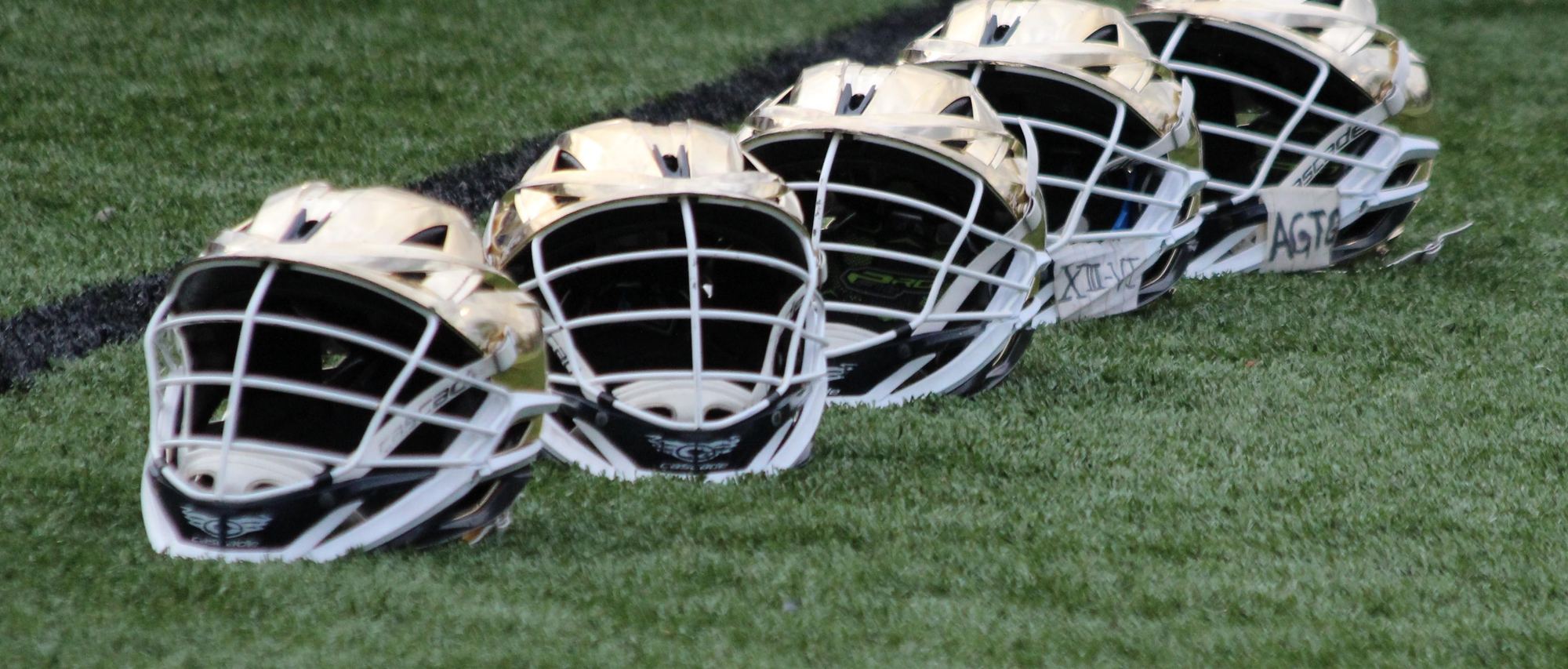 A row of SJJ gold helmets on the turf